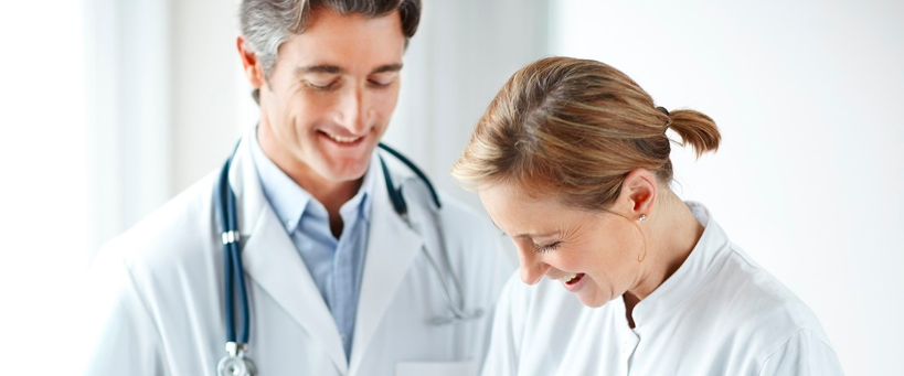 Two healthcare professionals engaged in a collaborative discussion, possibly about approaches to voice and speech disorder treatment.