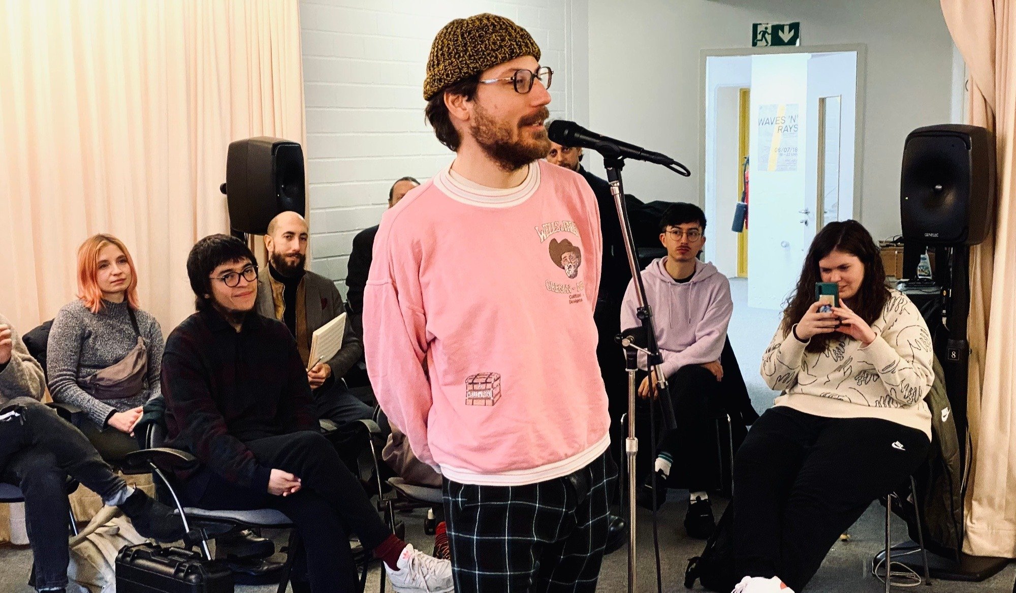 A musician speaks into a microphone at a gathering, embodying the collaborative spirit of musicians using Respeecher's voice cloning technology.